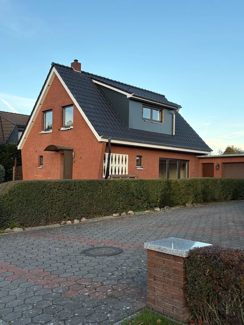 Fertiges rotes Klinkerhaus mit neuem Dach und Gaube, Gerüst abgebaut