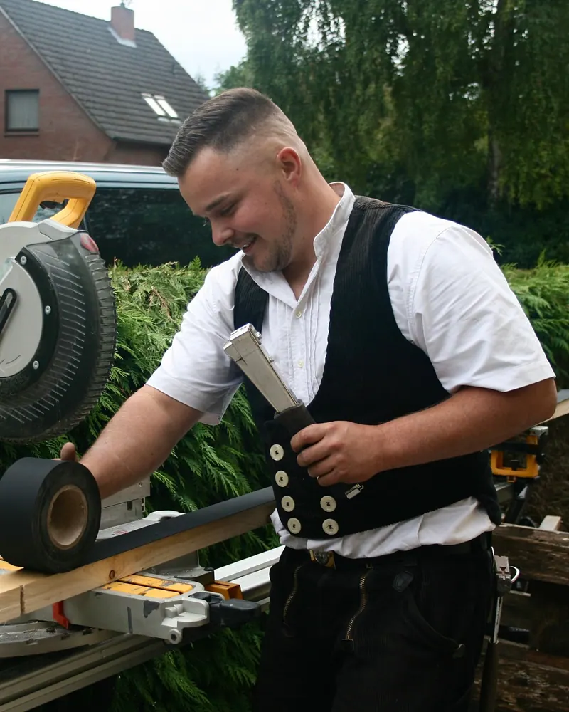Jonas Reents lachend an der Kappsäge im Garten